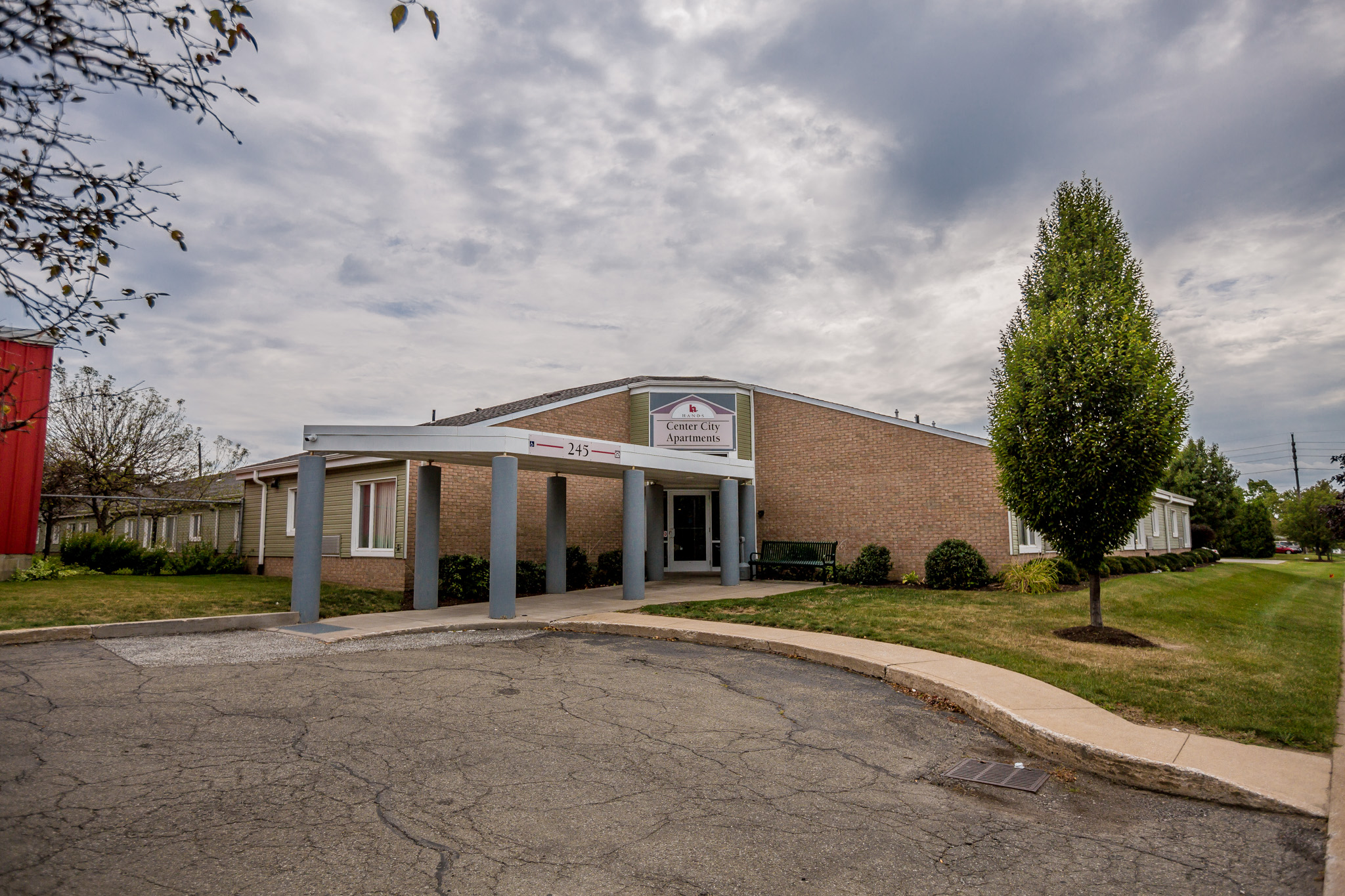 the front of a brick building with a covered parking lot
